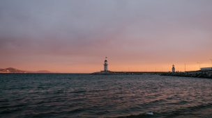 peaceful evening seashore with remote lighthouse